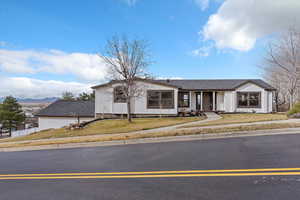 View of front of property featuring a front lawn, a porch, and stucco siding