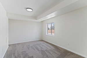 Empty room featuring carpet and baseboards