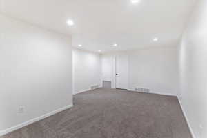 Empty room with carpet and recessed lighting