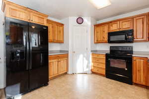 Kitchen featuring black appliances and light countertops