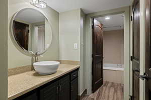Full bathroom featuring vanity, wood tiled floors, and recessed lighting