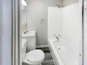 Full bath featuring vanity, shower / bathtub combination, and a textured wall