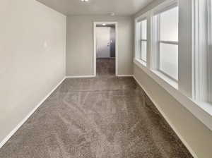 Carpeted spare room with baseboards
