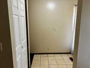 Unfurnished bedroom with light tile patterned floors and a closet