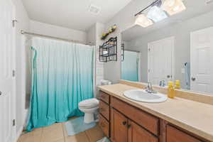 Bathroom with shower / bath combo, vanity, and light tile patterned floors