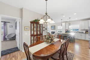 Dining room with light wood-style floors, a chandelier, and recessed lighting