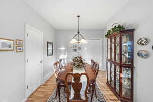 Dining room featuring light wood-style flooring and a chandelier