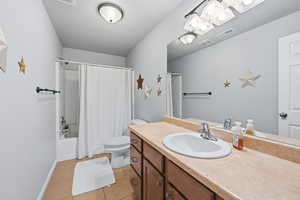 Bathroom with shower / bath combo, vanity, and light tile patterned floors