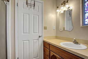 Full bath featuring vanity and a shower stall