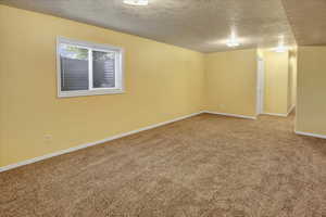 Spare room featuring a textured ceiling and carpet floors