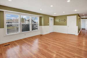 Unfurnished room featuring a wainscoted wall, recessed lighting, and light wood finished floors