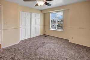 Unfurnished bedroom with a closet, a ceiling fan, and carpet