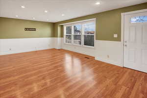 Foyer entrance featuring light wood-style floors, recessed lighting, and a wainscoted wall