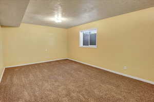 Carpeted empty room with a textured ceiling