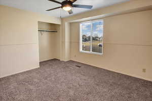 Unfurnished bedroom featuring carpet floors, a closet, and ceiling fan