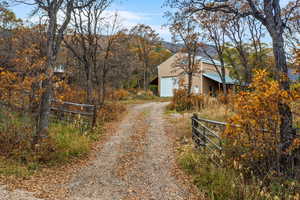 View of dirt / gravel driveway featuring a gated entry