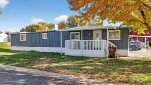 Manufactured / mobile home with a front lawn and board and batten siding