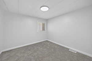 Carpeted spare room with baseboards