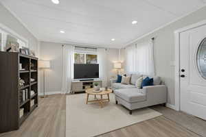 Living room with light wood-type flooring and baseboards virtual staged