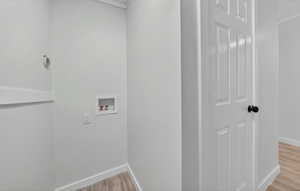 Laundry room with light wood finished floors and hookup for a washing machine
