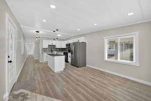 Kitchen with dark countertops, white cabinetry, appliances with stainless steel finishes, tasteful backsplash, and open floor plan