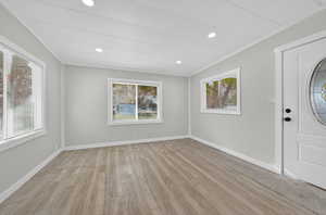 Entrance foyer with light wood-style flooring, crown molding, plenty of natural light, and recessed lighting