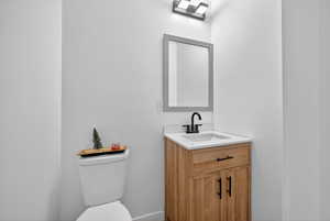 Half bathroom featuring vanity and toilet