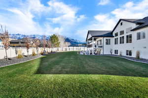 Fenced backyard featuring a balcony, a mountain view, and a patio