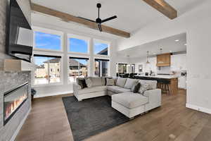 Living area featuring a fireplace, healthy amount of natural light, light wood-style flooring, beam ceiling, and recessed lighting