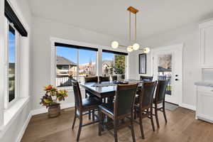 Dining room with light wood-style floors and a chandelier