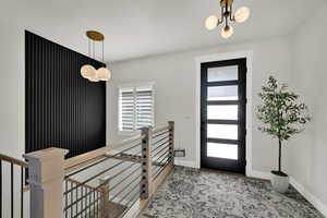Foyer with a chandelier and baseboards
