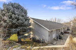 View of home's exterior featuring roof with shingles and stucco siding