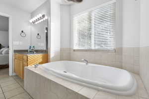 Full bath with a garden tub, connected bathroom, vanity, and light tile patterned floors