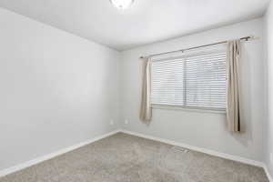Carpeted spare room with baseboards