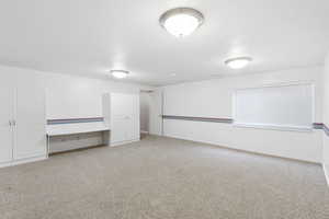 Below grade area featuring light carpet and baseboards