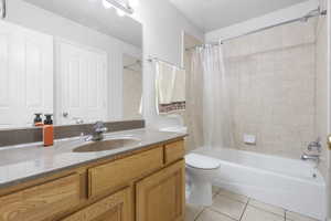 Bathroom featuring shower / tub combo, vanity, and light tile patterned floors