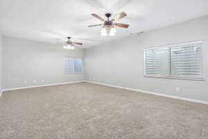 Unfurnished room with carpet flooring and a ceiling fan