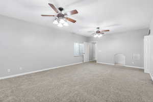 Spare room featuring light carpet and a ceiling fan