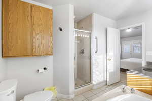 Bathroom featuring a stall shower, light tile patterned floors, ensuite bathroom, vanity, and a bath