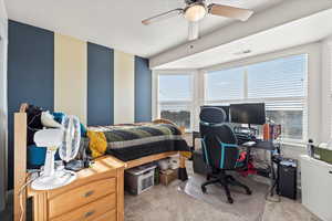 Bedroom with light carpet, an office area, a ceiling fan, and a textured ceiling