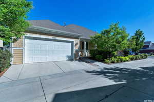 View of front of property with driveway, an attached garage, roof with shingles, and a porch