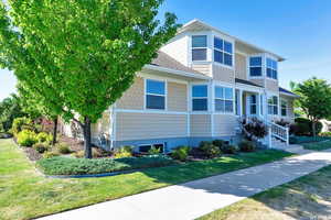 View of front of home featuring a front yard and a shingled roof