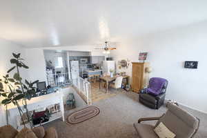 Living area with a ceiling fan and vaulted ceiling