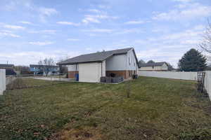 View of side of home featuring a fenced backyard, brick siding, a patio area, and a shingled roof