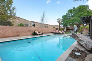 View of swimming pool with a patio, a fenced backyard, and a pergola