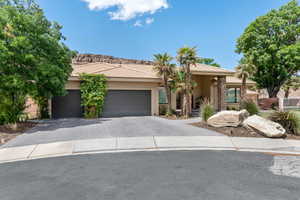 View of front facade with decorative driveway, a garage, stucco siding, stone siding, and a tiled roof