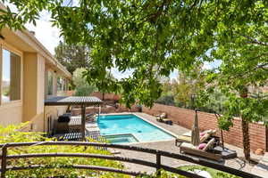 View of pool with a gazebo, a fenced backyard, a patio area, and a pool with connected hot tub