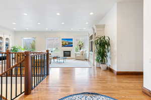 Entrance foyer with a glass covered fireplace, light wood-type flooring, and recessed lighting