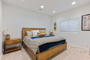 Bedroom with light carpet and recessed lighting