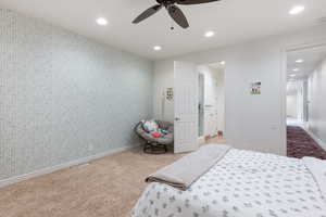 Bedroom with wallpapered walls, an accent wall, ceiling fan, and recessed lighting